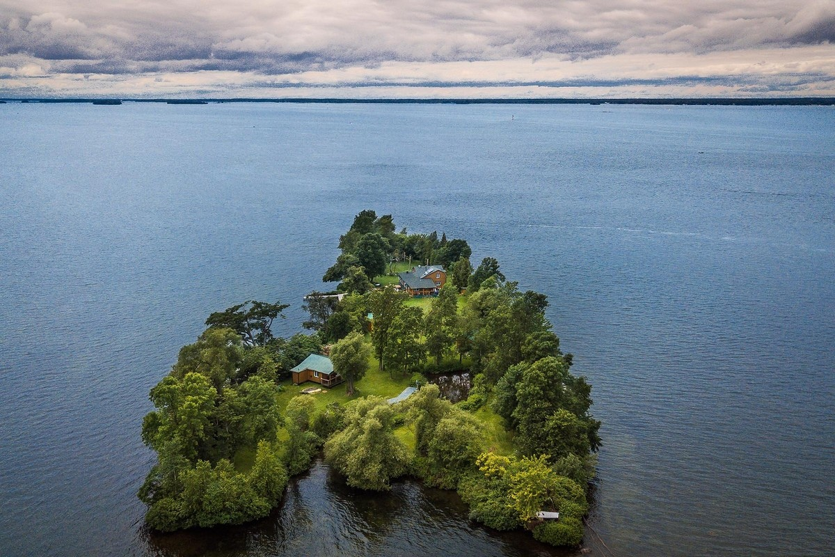Уединенный дом с другими постройками на острове посреди воды