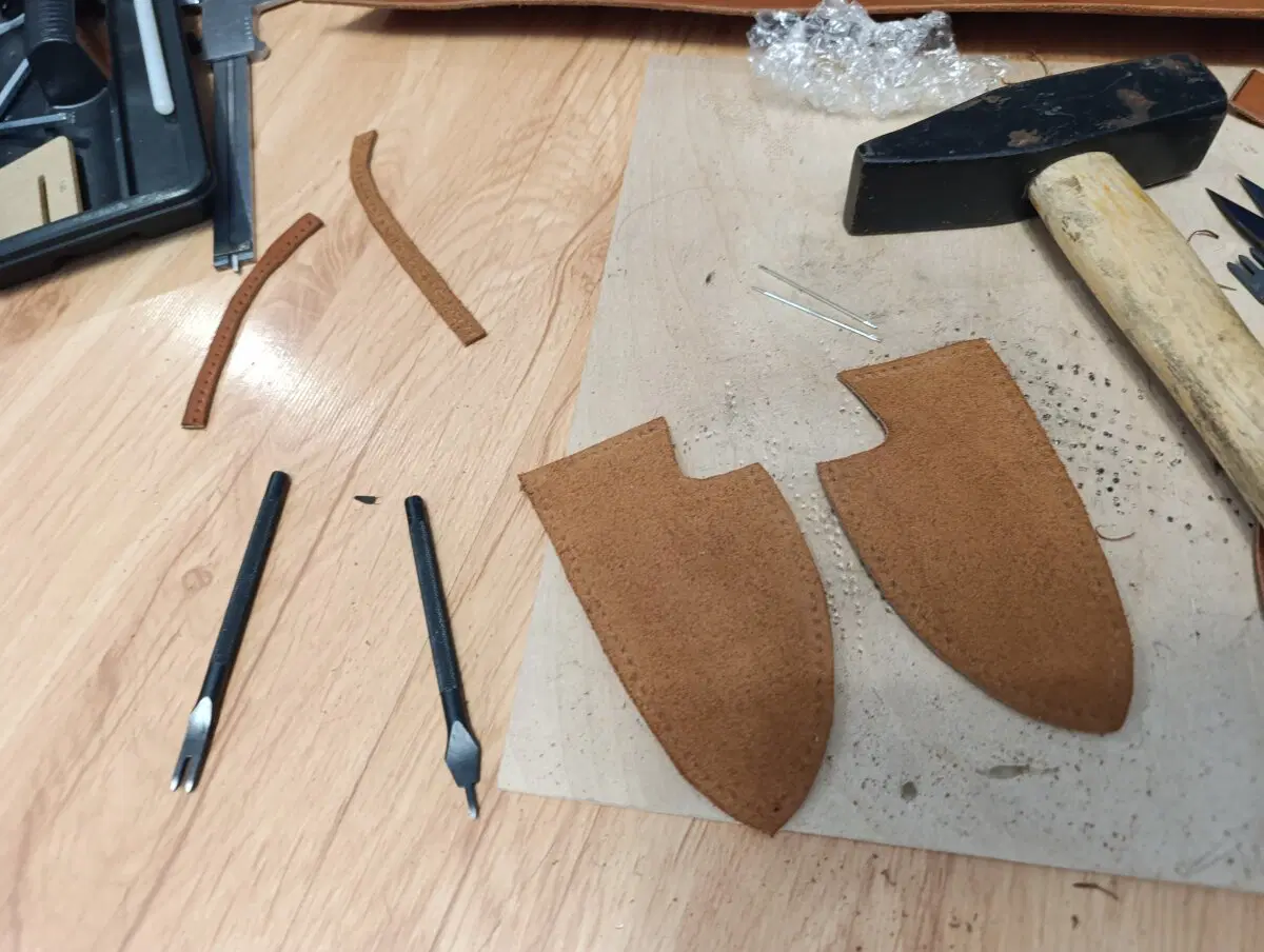 С лоскутков кожи вырезаю части и пробиваем отверстия для сшивания