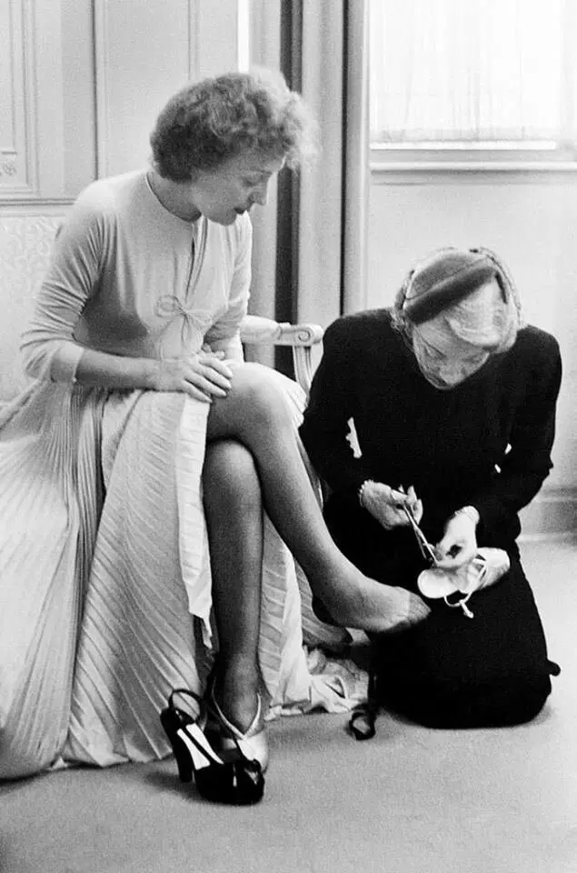 Марлен Дитрих помогает Эдит Пиаф со свадебной туфелькой в день свадьбы Пиаф, 1952 год.