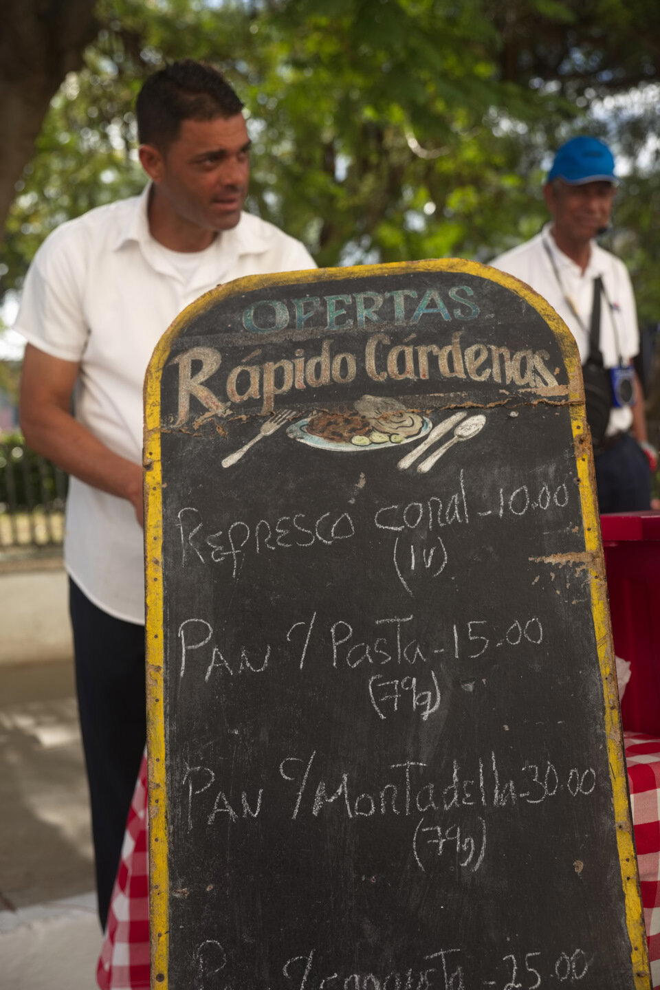 Школьники на соседней площади танцевали в честь праздника. Уличные торговцы рядом торговали. Цены на перекусы сфотал.