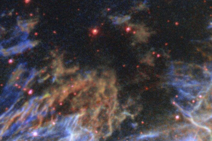 Далекие фоновые звезды выглядят красными, потому что окружающие газ и пыль поглощают синий свет сильнее красного. До нас доходит в основном красная часть спектра / © ESA/Hubble &amp; NASA, S. Kulkarni, Y. Chu